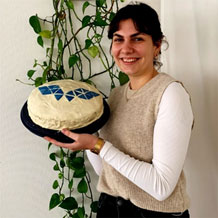 Mitarbeiterin mit Kuchen in der Hand